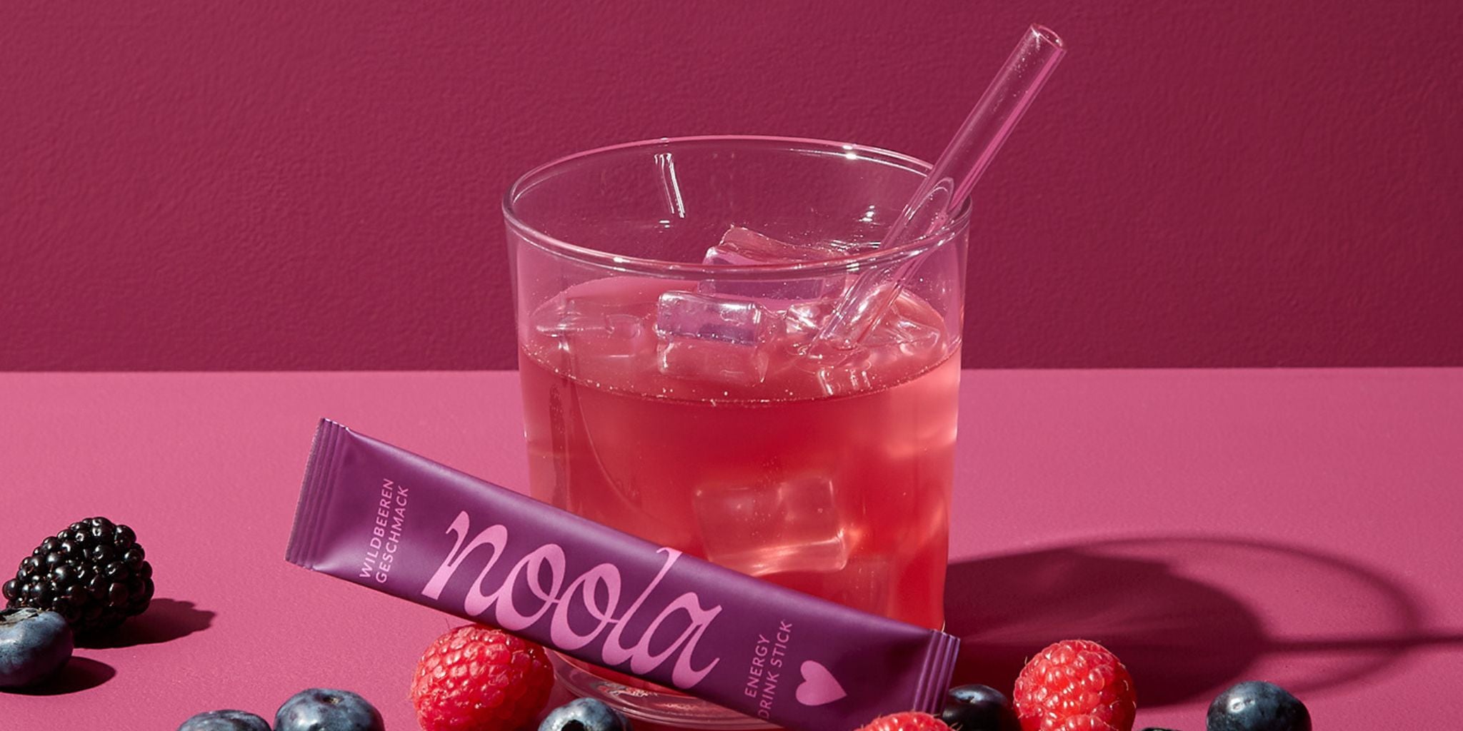 noola Energy Drink Wildbeere im Glas mit frischen Waldbeeren
