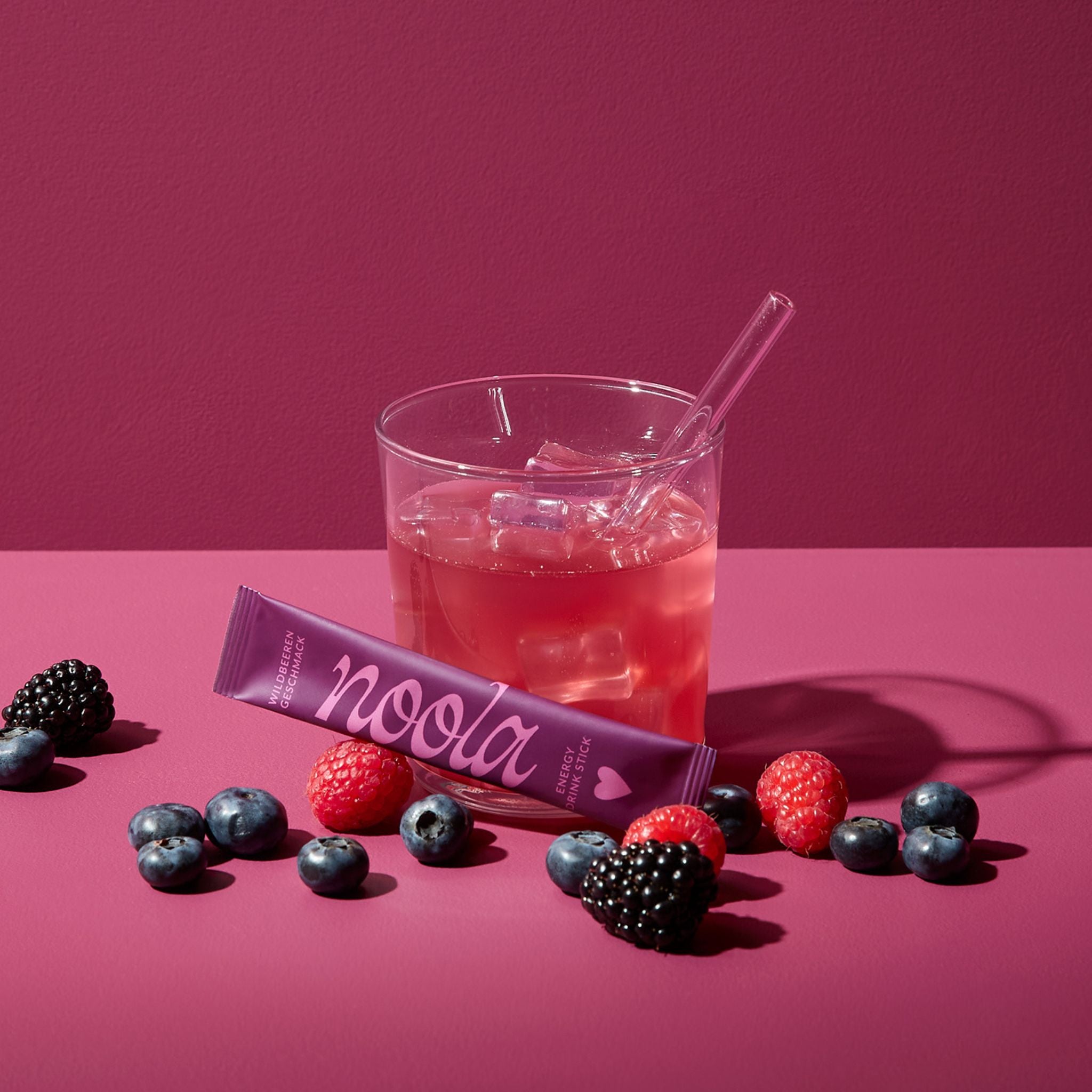 noola Energy Drink Wildbeere im Glas mit frischen Waldbeeren