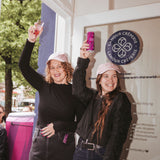 Zwei Frauen tragen die noola Good Energy Cap in Blush